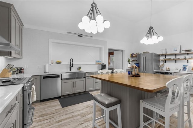 kitchen with an inviting chandelier, appliances with stainless steel finishes, a sink, and gray cabinets