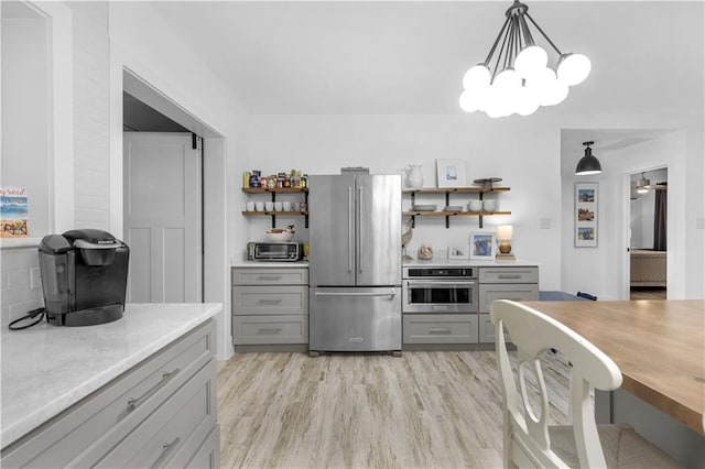 kitchen with open shelves, light countertops, gray cabinets, and stainless steel appliances