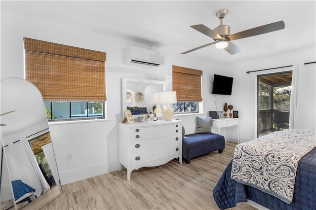 bedroom with multiple windows, light wood-style floors, access to exterior, and an AC wall unit