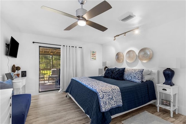 bedroom featuring a ceiling fan, light wood-style flooring, visible vents, rail lighting, and access to exterior