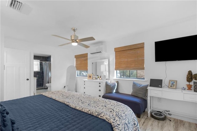 bedroom featuring ceiling fan, a wall mounted air conditioner, visible vents, and wood finished floors