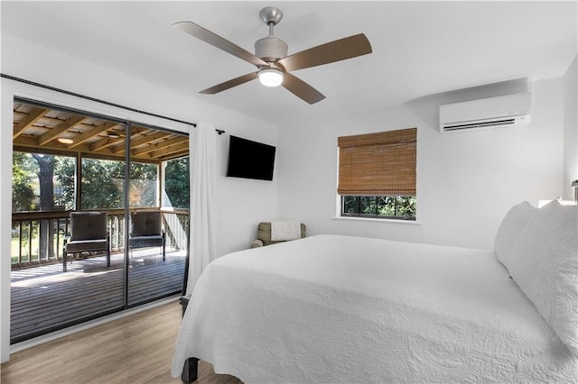bedroom with ceiling fan, wood finished floors, a wall mounted AC, and access to exterior