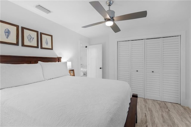 bedroom with a closet, light wood-style floors, visible vents, and a ceiling fan
