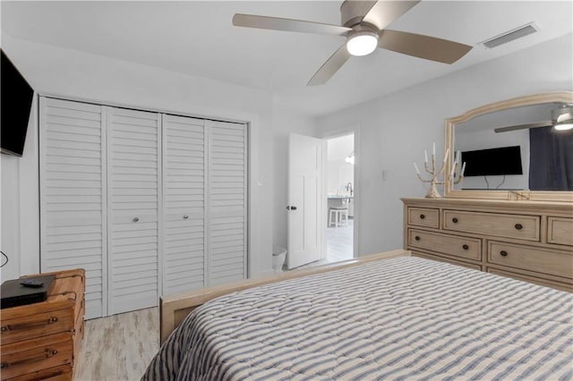 bedroom featuring a closet, a ceiling fan, visible vents, and light wood-style floors