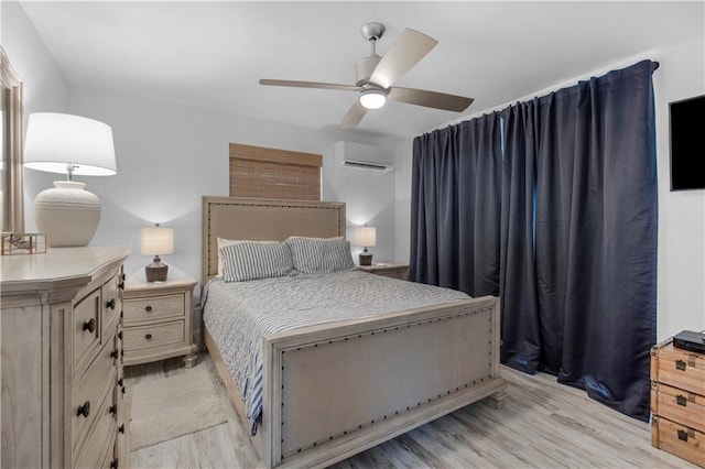 bedroom with light wood finished floors, a wall mounted AC, and a ceiling fan