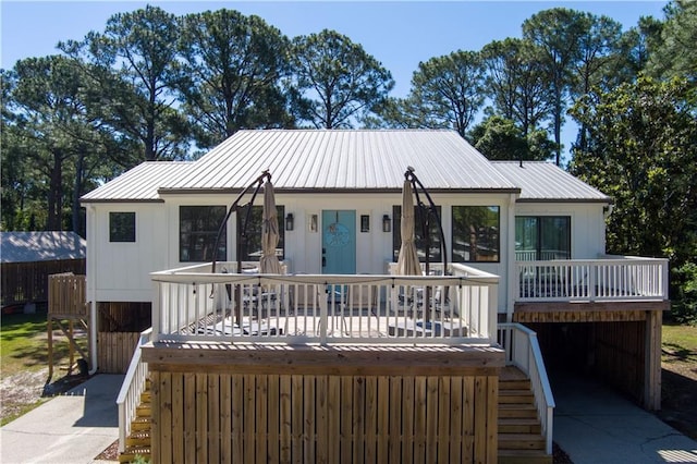 rear view of house featuring metal roof and stairway