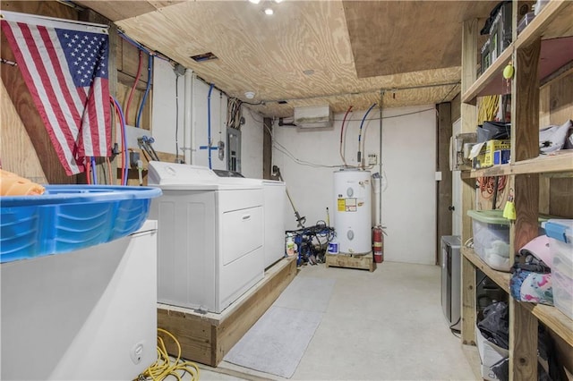 unfinished below grade area featuring electric water heater, washer and clothes dryer, and electric panel