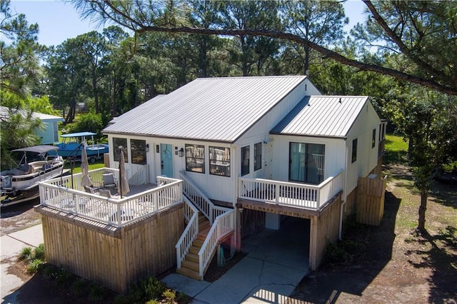 rear view of property featuring metal roof and stairs