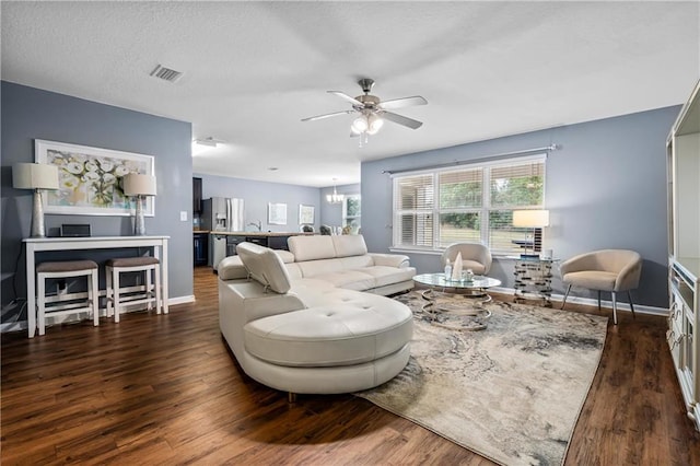 living room with dark hardwood / wood-style floors and ceiling fan with notable chandelier