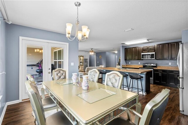 1951 Stonepine Dr, Semmes, AL 36575 - dining space featuring dark wood-type flooring, french doors, a chandelier, and a ceiling fan