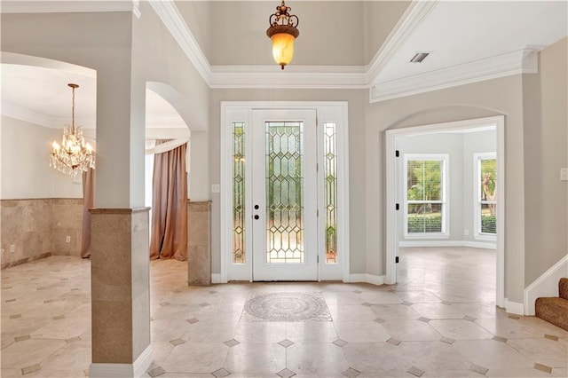 entrance foyer with crown molding and an inviting chandelier