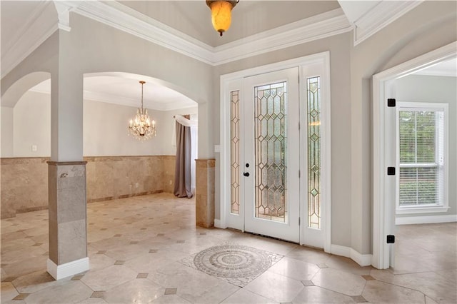 foyer featuring an inviting chandelier, tile walls, and crown molding