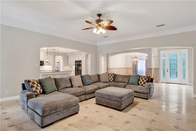 living room featuring ceiling fan with notable chandelier and crown molding