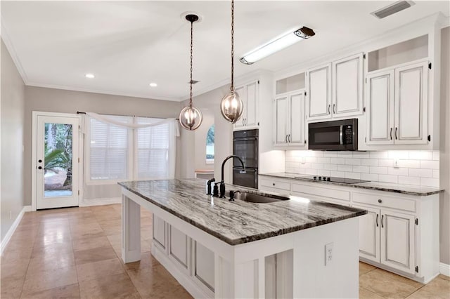 kitchen featuring white cabinetry, sink, an island with sink, dark stone counters, and black appliances