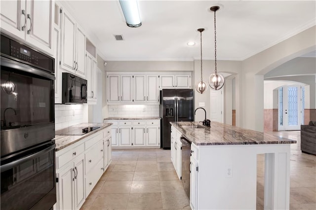 kitchen featuring black appliances, white cabinets, and a kitchen island with sink