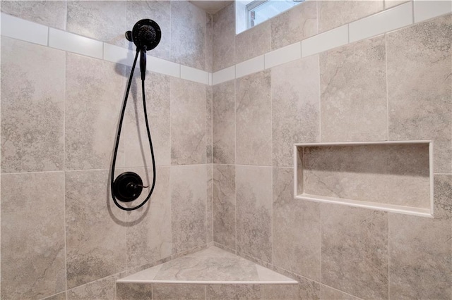 interior details featuring tiled shower