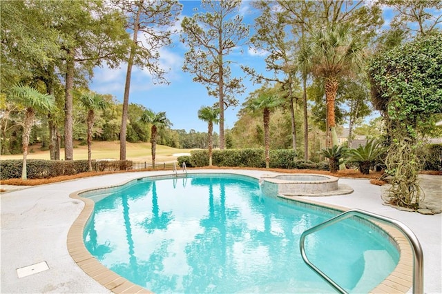 view of swimming pool with an in ground hot tub