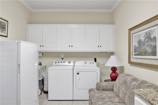 30077 River Rd, Orange Beach, AL 36561 - laundry area featuring separate washer and dryer, crown molding, cabinet space, and light tile patterned floors