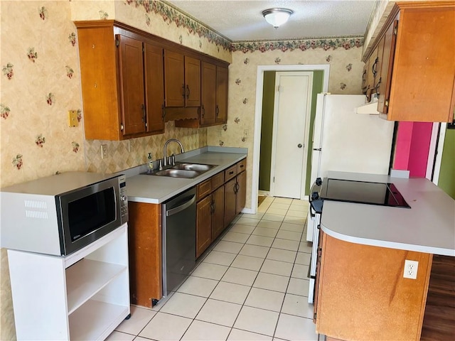 kitchen with stainless steel appliances, sink, a textured ceiling, and light tile patterned floors