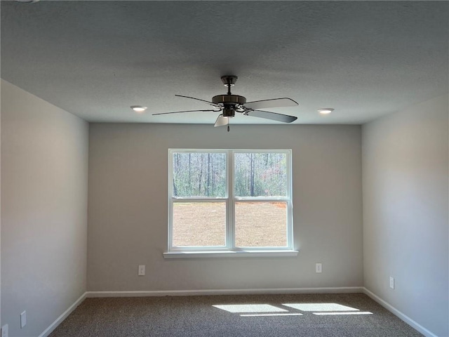 unfurnished room featuring a textured ceiling, carpet, and ceiling fan