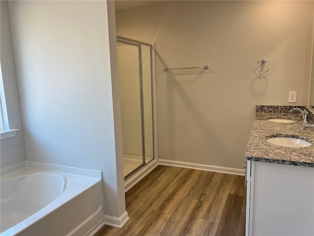 bathroom featuring shower with separate bathtub, double vanity, and hardwood / wood-style flooring