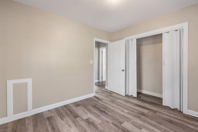 unfurnished bedroom with hardwood / wood-style floors and a closet