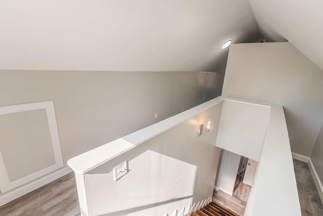 stairs with wood-type flooring and vaulted ceiling