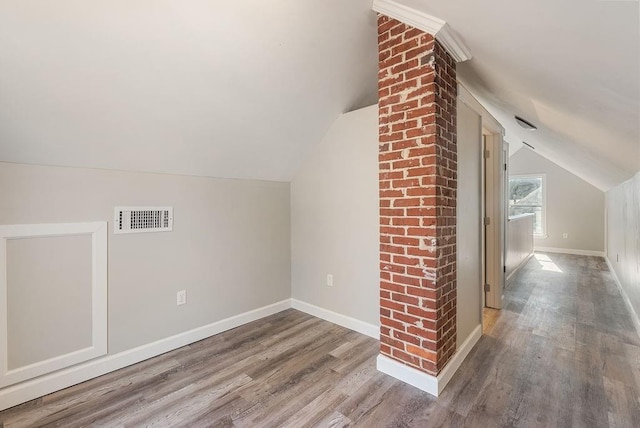 additional living space featuring hardwood / wood-style floors and vaulted ceiling