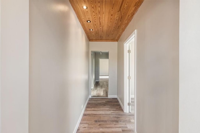 hall with light wood-type flooring and wood ceiling