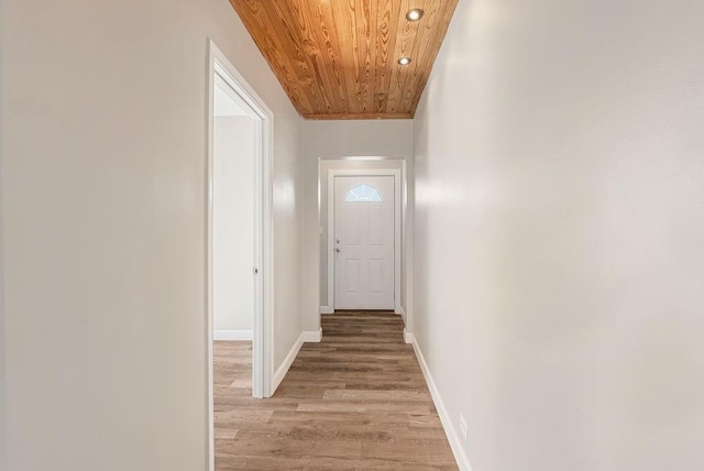 hall with light hardwood / wood-style floors and wooden ceiling