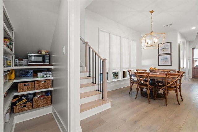 dining space featuring an inviting chandelier, light hardwood / wood-style floors, and a wealth of natural light