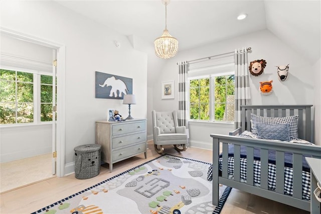 bedroom with wood-type flooring, vaulted ceiling, and a notable chandelier