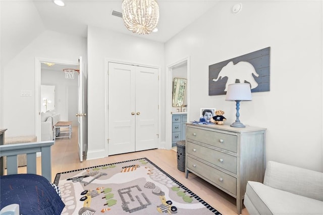 bedroom with an inviting chandelier, a closet, and light wood-type flooring