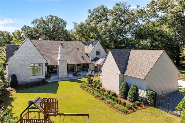 rear view of property with a lawn and a playground