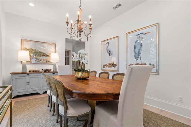 dining area featuring light hardwood / wood-style flooring and a chandelier