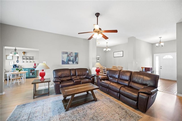 living room featuring light wood-type flooring and ceiling fan with notable chandelier