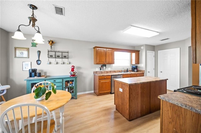 kitchen with dishwasher, light hardwood / wood-style floors, a textured ceiling, hanging light fixtures, and a kitchen island