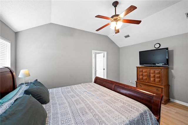 bedroom with ceiling fan, light wood-type flooring, and vaulted ceiling