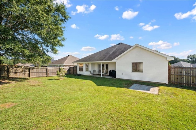 rear view of property featuring a lawn and a patio area