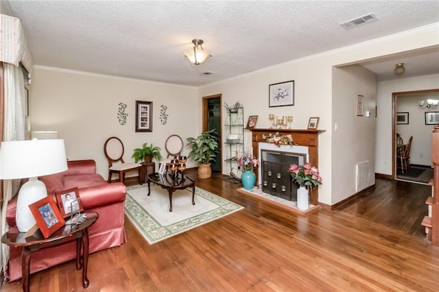 1406 Windsor Ave, Mobile, AL 36605 - living room featuring wood finished floors, a textured ceiling, crown molding, a fireplace, and baseboards