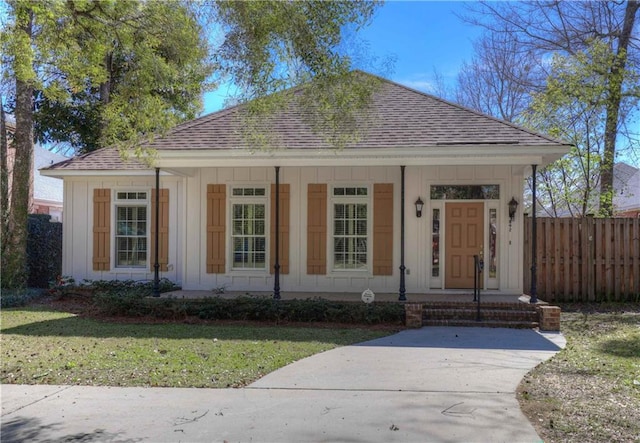 bungalow-style house featuring board and batten siding, a porch, a shingled roof, and fence