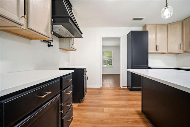 5108 Highcrest Dr, Mobile, AL 36693 - kitchen featuring light countertops, light wood-style flooring, wall chimney range hood, decorative light fixtures, and light brown cabinets