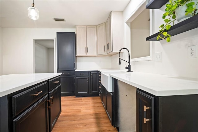 5108 Highcrest Dr, Mobile, AL 36693 - kitchen featuring light countertops, dark cabinetry, light wood finished floors, and hanging light fixtures