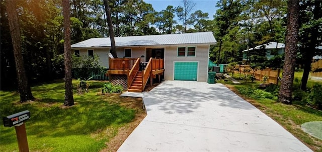 view of front of property featuring a front yard, a deck, and a garage