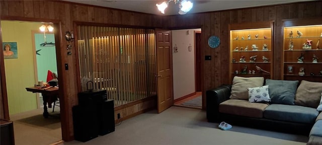 carpeted living room featuring crown molding, ceiling fan, and wooden walls