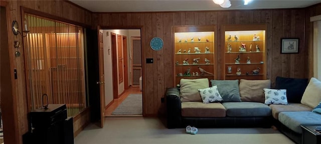 carpeted living room with wood walls