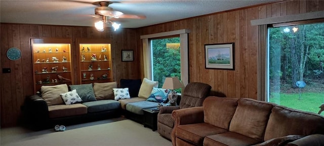 living room featuring ceiling fan and wooden walls