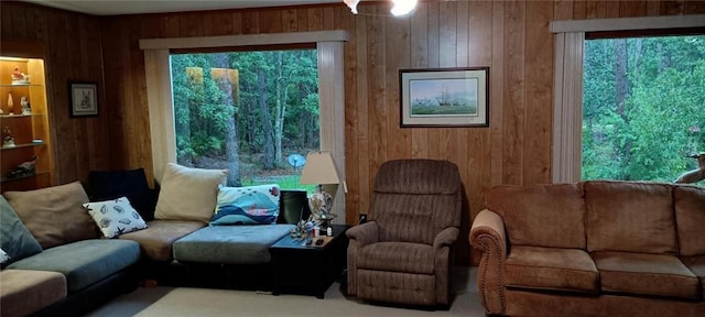 carpeted living room featuring wooden walls