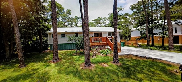 view of front of house with a front yard and a wooden deck