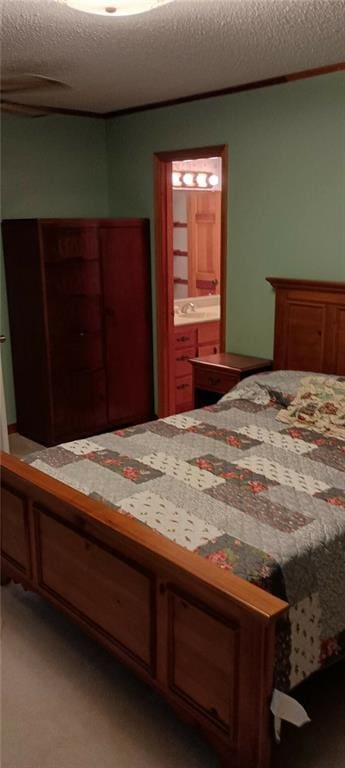 carpeted bedroom with ensuite bathroom and a textured ceiling